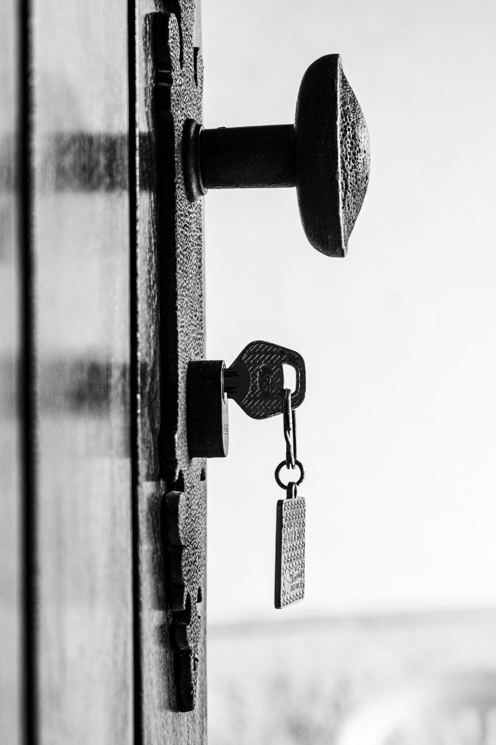 Clé laissée sur la serrure d'une porte en bois entrouverte